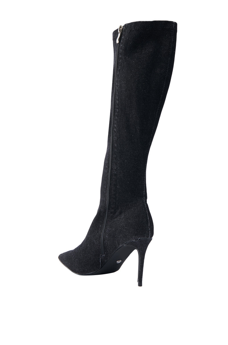 The AZALEA WANG VILLAREAL DENIM BOOT WITH TIES is a sleek black knee-high boot with a pointed toe and stiletto heel, featuring a side zipper for closure and boasting a smooth texture that combines elegance with edgy style.