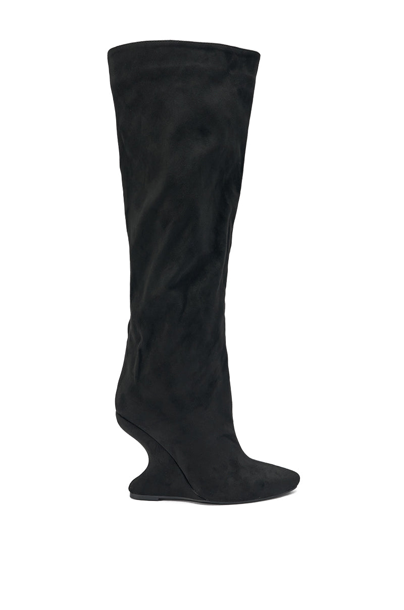 The AZALEA WANG VINCE BLACK FAUX SUEDE WEDGE BOOT is a tall, knee-high black wedge boot with a pointed toe and sculpted heel, beautifully showcased against a white background.