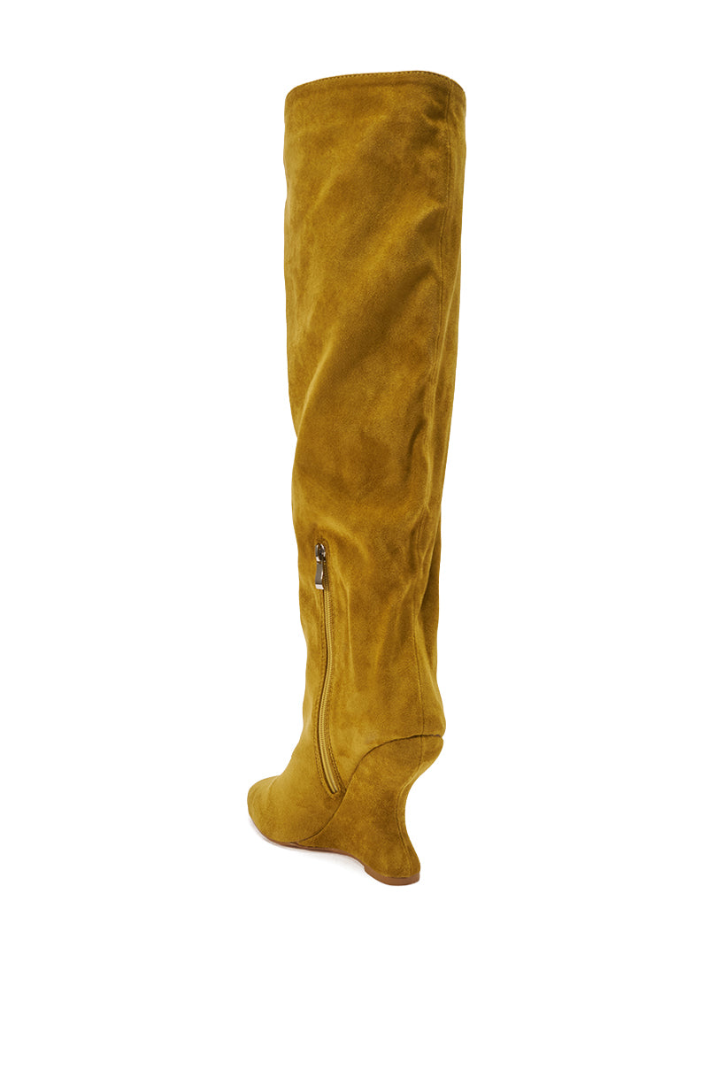 The AZALEA WANG VINCE MUSTARD FAUX SUEDE WEDGE BOOT features a pointed toe, side zipper, and curved wedge heel in mustard yellow faux suede, shown in a single shoe photo against a white background.