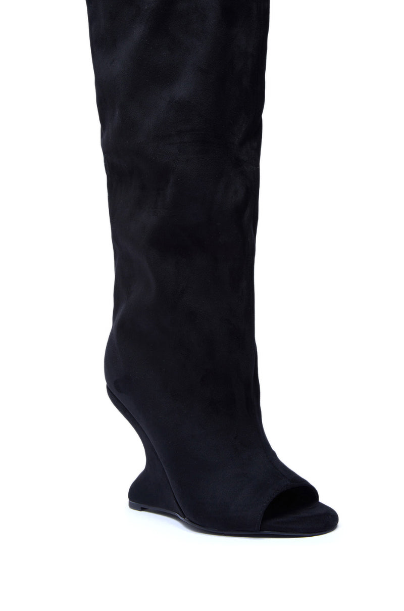The AZALEA WANG VINCENT BLACK FAUX SUEDE OPEN TOE BOOT is a knee-high design featuring a unique sculpted wedge heel, shown in black faux suede against a white background.
