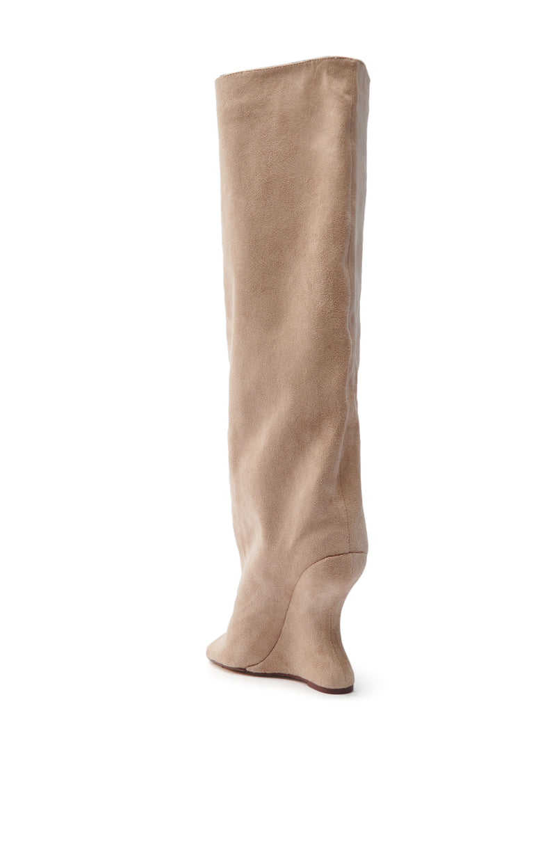 The AZALEA WANG VINCENT NUDE OPEN TOE WEDGE BOOT is a single tan knee-high faux suede boot featuring a smooth texture, slightly slouched mid-calf, and a concealed wedge heel. The subtly angled toe faces right, all set against a white backdrop.