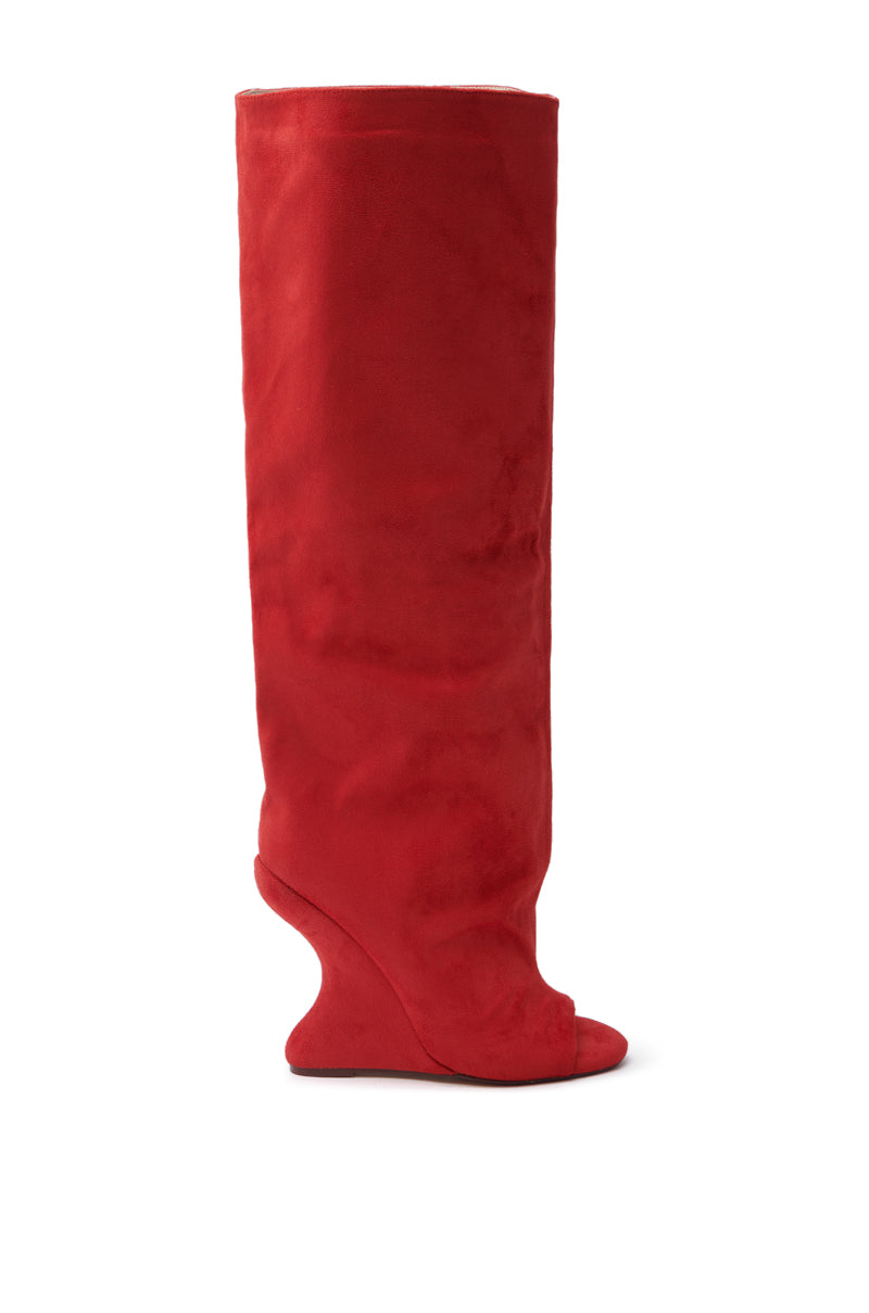 The AZALEA WANG VINCENT RED OPEN TOE WEDGE BOOT features a soft faux suede upper with an inverted wedge heel. This knee-high boot stands out against a plain white background, showcasing its modern and artistic design.