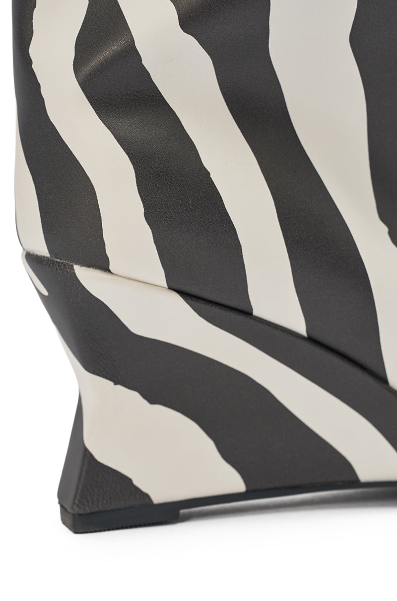 Close-up of a bag’s sharp, angular corner in black and white zebra print—perfectly paired with the AZALEA WANG VINCI ZEBRA PU PRINT WEDGE BOOTIE for a coordinated, bold look. 5