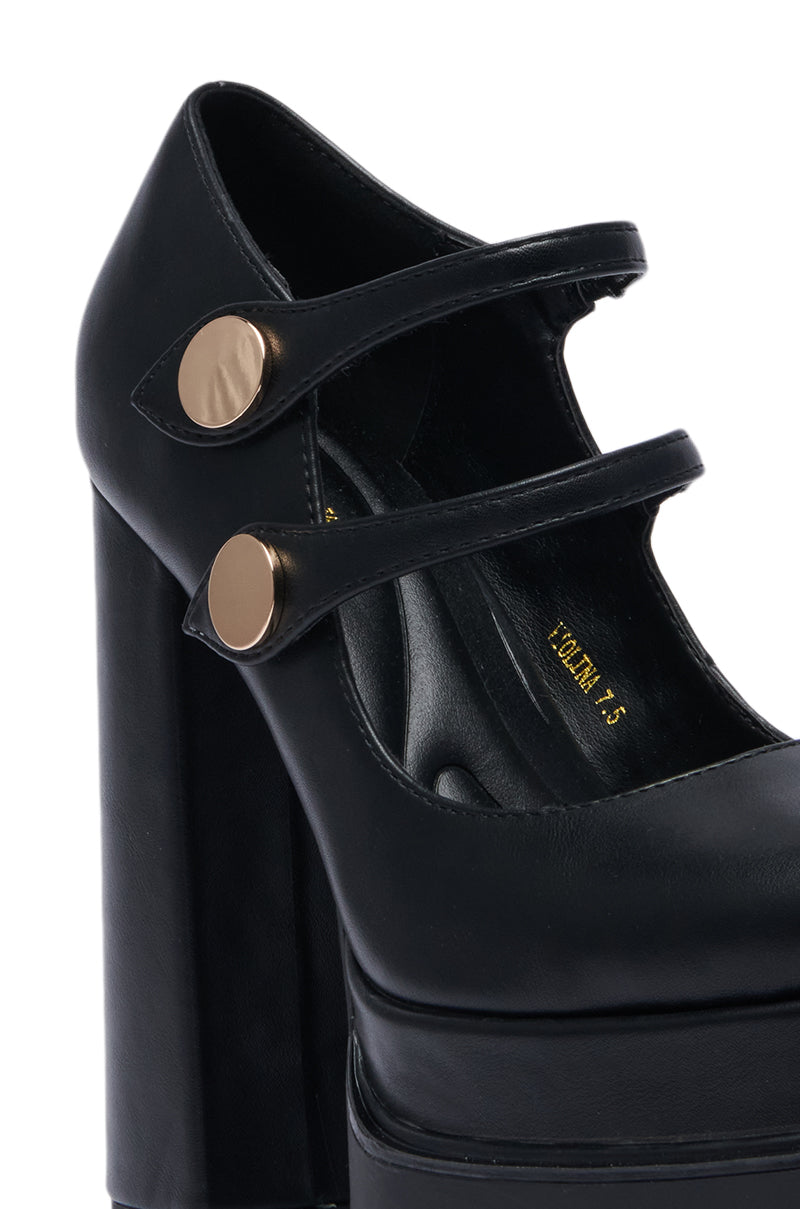 The AZALEA WANG VIOLINA BLACK CHUNKY PLATFORM PUMP boasts a sleek faux leather upper, featuring two adjustable straps adorned with round gold buttons. Its stylish design includes a square toe and a sophisticated finish. 5
