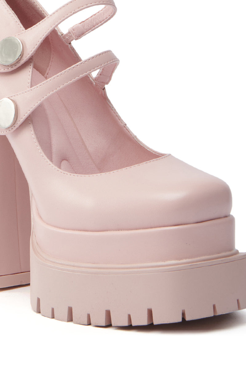 The AZALEA WANG VIOLINA Pink Chunky Platform Pump showcases a close-up of a pink shoe with a square toe and thick ridged sole. It features two front straps, each secured with a metallic button, and smooth material resembling vegan leather. 5