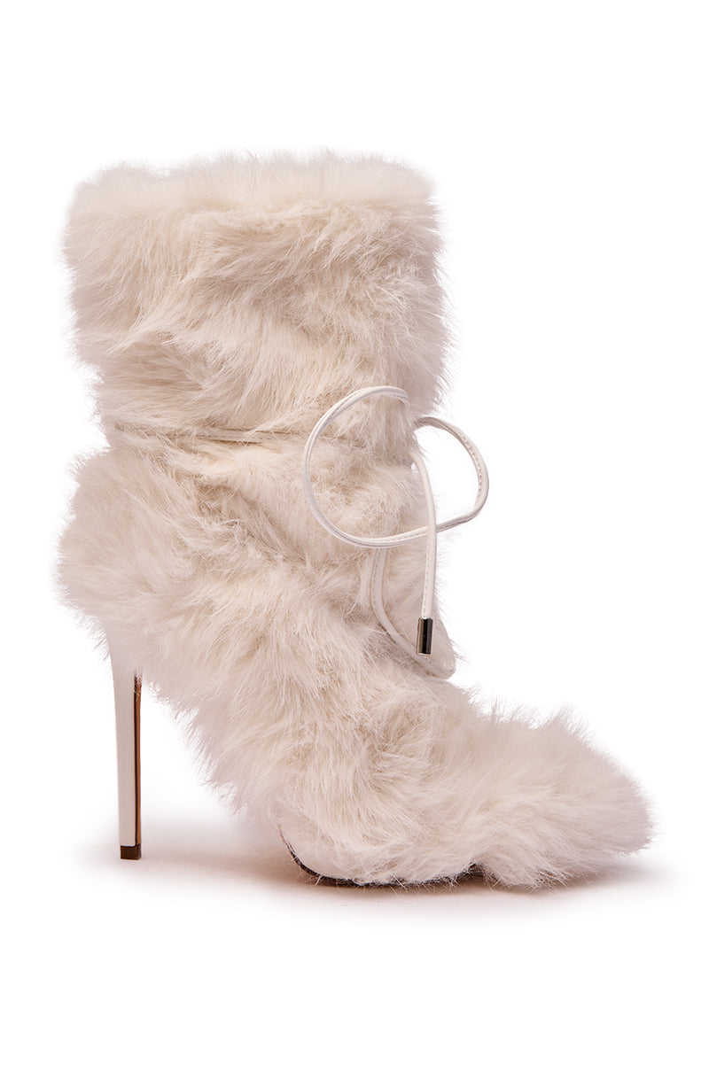 The AZALEA WANG VITYA IVORY FUR BOOTIE is a white faux fur mid-calf bootie with a metallic stiletto heel and a white cord tied around the ankle.