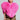 Confidently styled, a person showcases the STAR CROSSED LOVER FAUX FUR HEART VEST, a large and fluffy pink heart-shaped piece, layered over a bold leopard print ensemble. With their hair braided, they pose against a simple gray background.