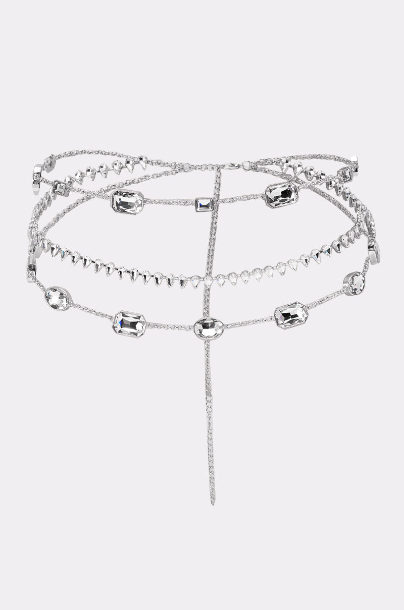 The GLITZ AND GLAM CHAIN BELT features layered silver chains with clear gemstone accents and delicate links, designed to drape elegantly around your waist and hips. 1