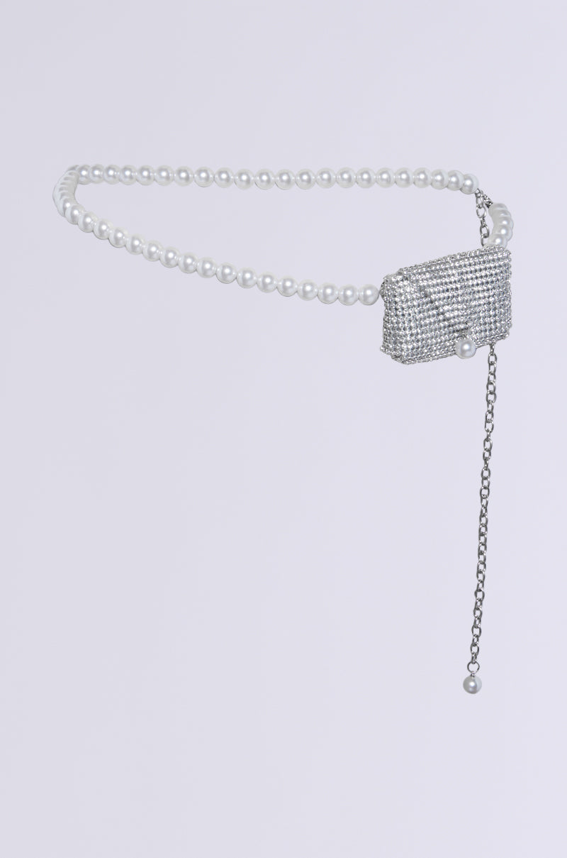 The "KEEP IT SAFE BLING BELT MINI BAG" is adorned with pearls, a silver rhinestone-encrusted buckle, and a stylish dangling chain accented with a single pearl, all set against a simple gray background.