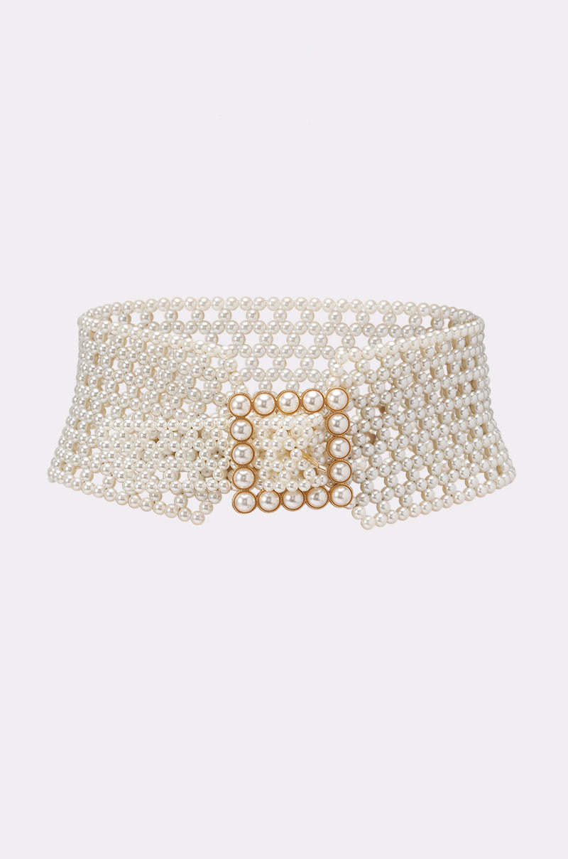 The PEARL PLEASE BELT features a wide, adjustable design crafted from small white pearls and is finished with a square, pearl-encrusted buckle at its center, making it the perfect statement accessory to add elegance to any outfit.