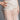 Wearing a sheer white lace dress with intricate patterns, the model showcases the STAY DRIPPIN PEARL BELT—an eye-catching faux pearl and bead statement piece draped at the waist. One hand rests on her hip; image is cropped at the torso.