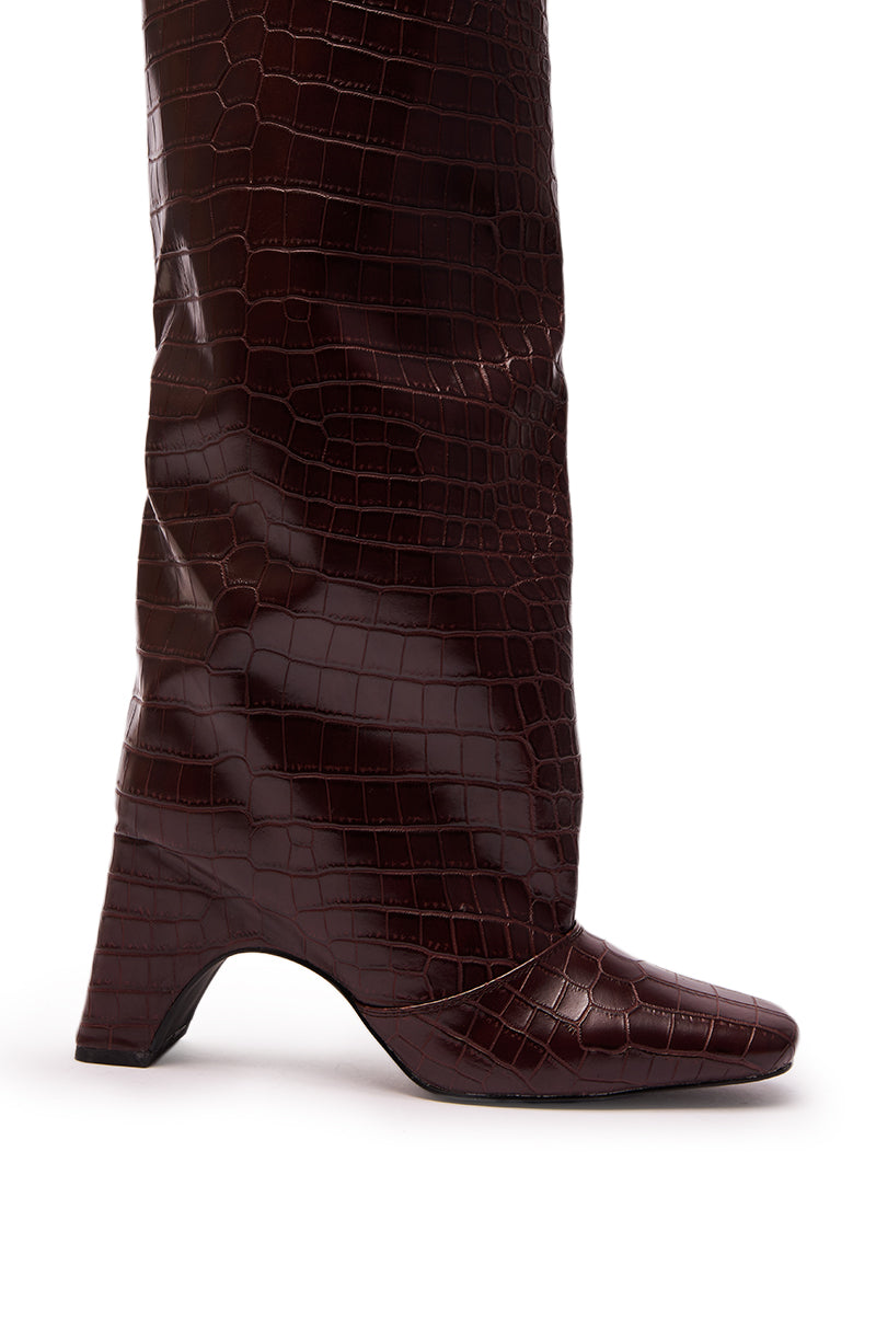 A close-up side view of the AZALEA WANG WELLS NEW BURGUNDY CROC BOOT, featuring a knee-high cut, chunky heel, and pointed toe, set against a white background.
