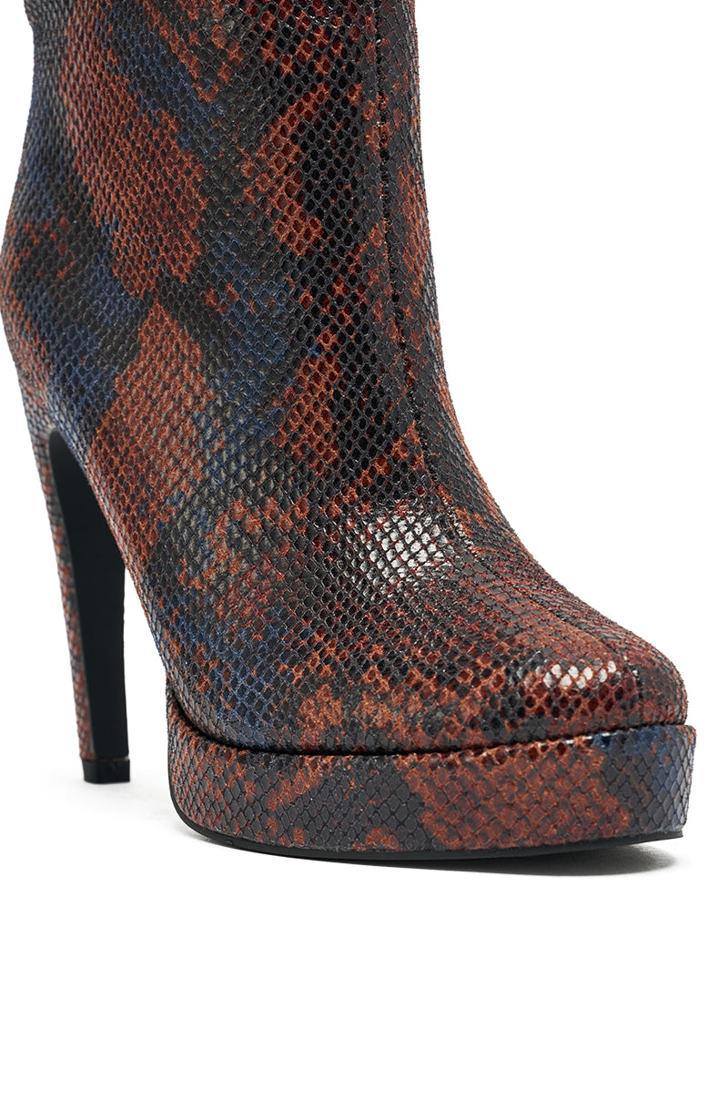 A close-up of the AZALEA WANG WENONA BROWN MULTI SNAKE BOOTIE, featuring faux snakeskin mid-calf boots with a platform sole and a textured, multicolored brown, black, and blue pattern.