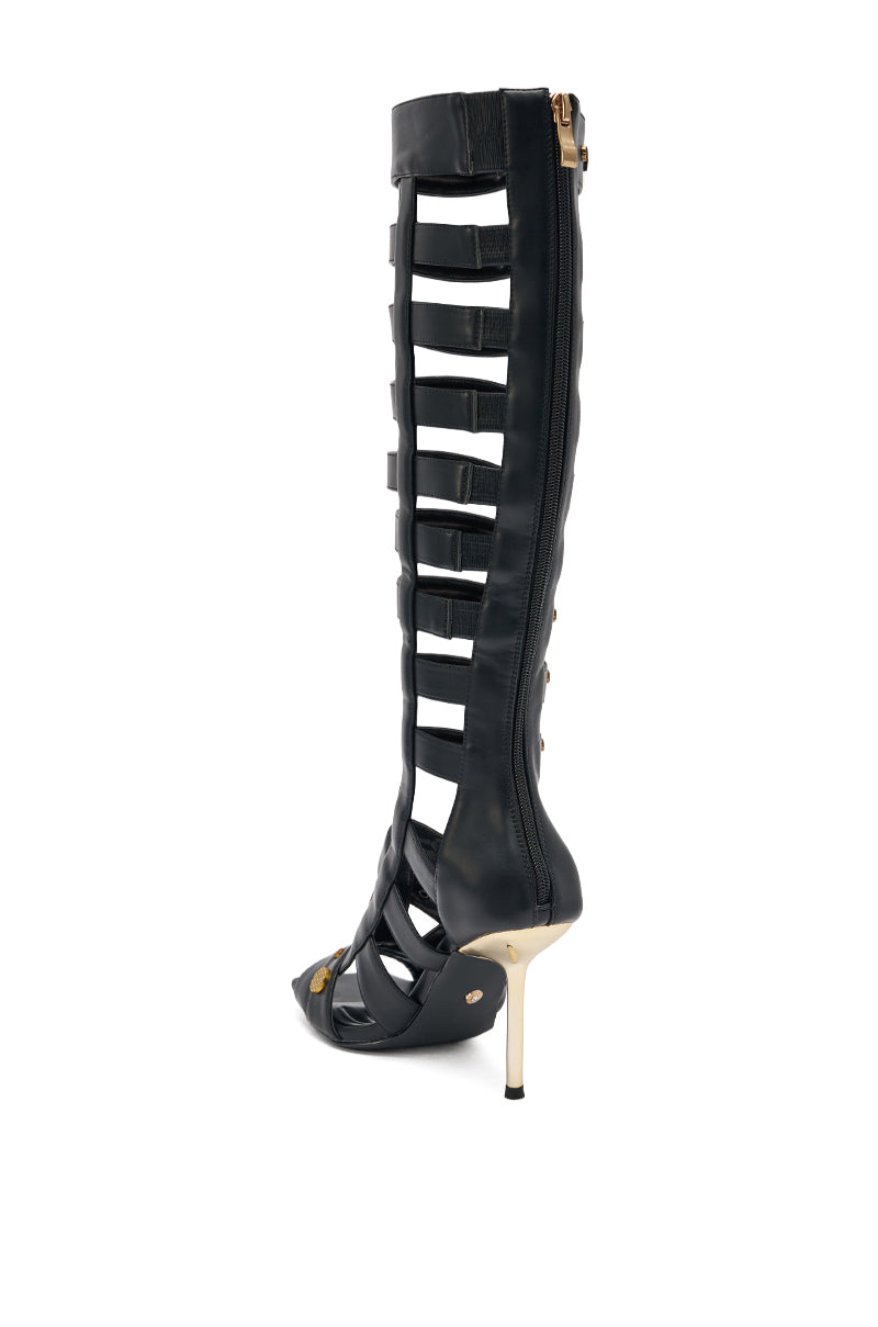 The AZALWA WANG GOLD WENTWORTH GLADIATOR sandal is a black knee-high, open-toe style with multiple horizontal straps, two-toned hardware embellishments, a gold stiletto heel, and a back zipper. 4