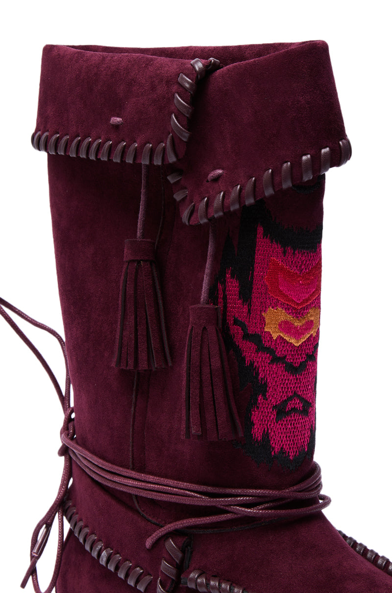 The AZALEA WANG WERET PLUM FLAT BOOTIE features faux suede, dark leather lacing, tassels, red and pink woven patterns, a folded-over top edge, and decorative stitching for a bohemian look.