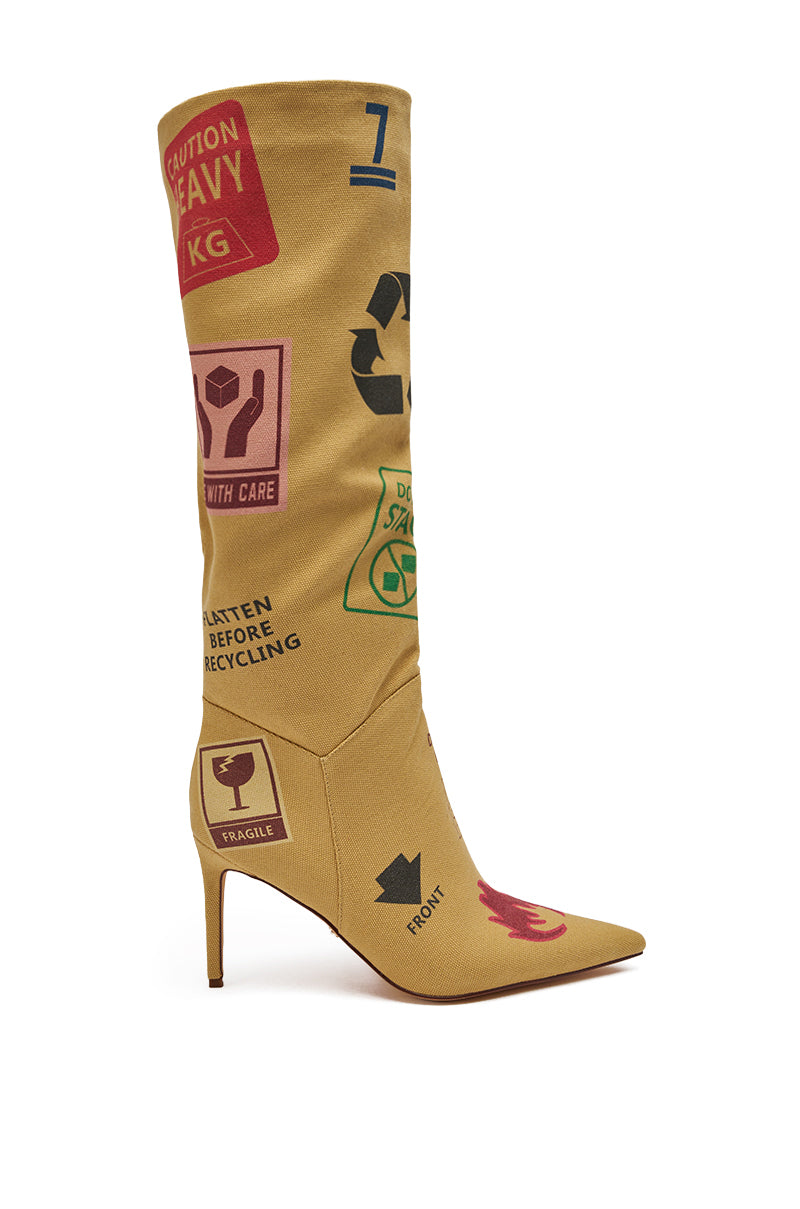 The AKIRA GOLD WHOLE PACKAGE TAN STILETTO BOOT is a knee-high, pointed toe stiletto featuring colorful shipping and recycling symbols like "Handle with care," a recycling logo, and "Fragile" for a bold, unique look. 6