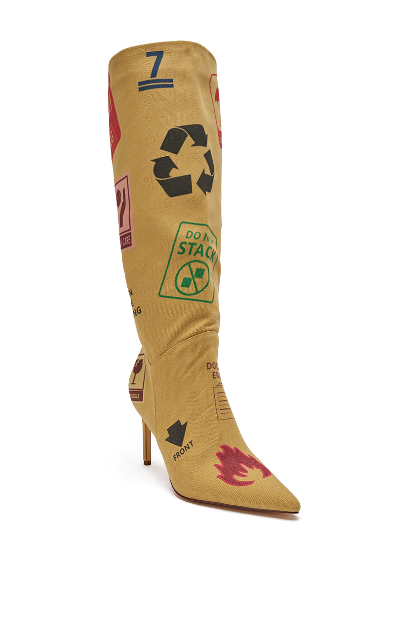 The AKIRA GOLD WHOLE PACKAGE TAN STILETTO BOOT is a pointed-toe, knee-high tan boot featuring bold, colorful warning symbols and shipping labels like arrows, recycling signs, flames, and handling icons for an edgy statement. 7