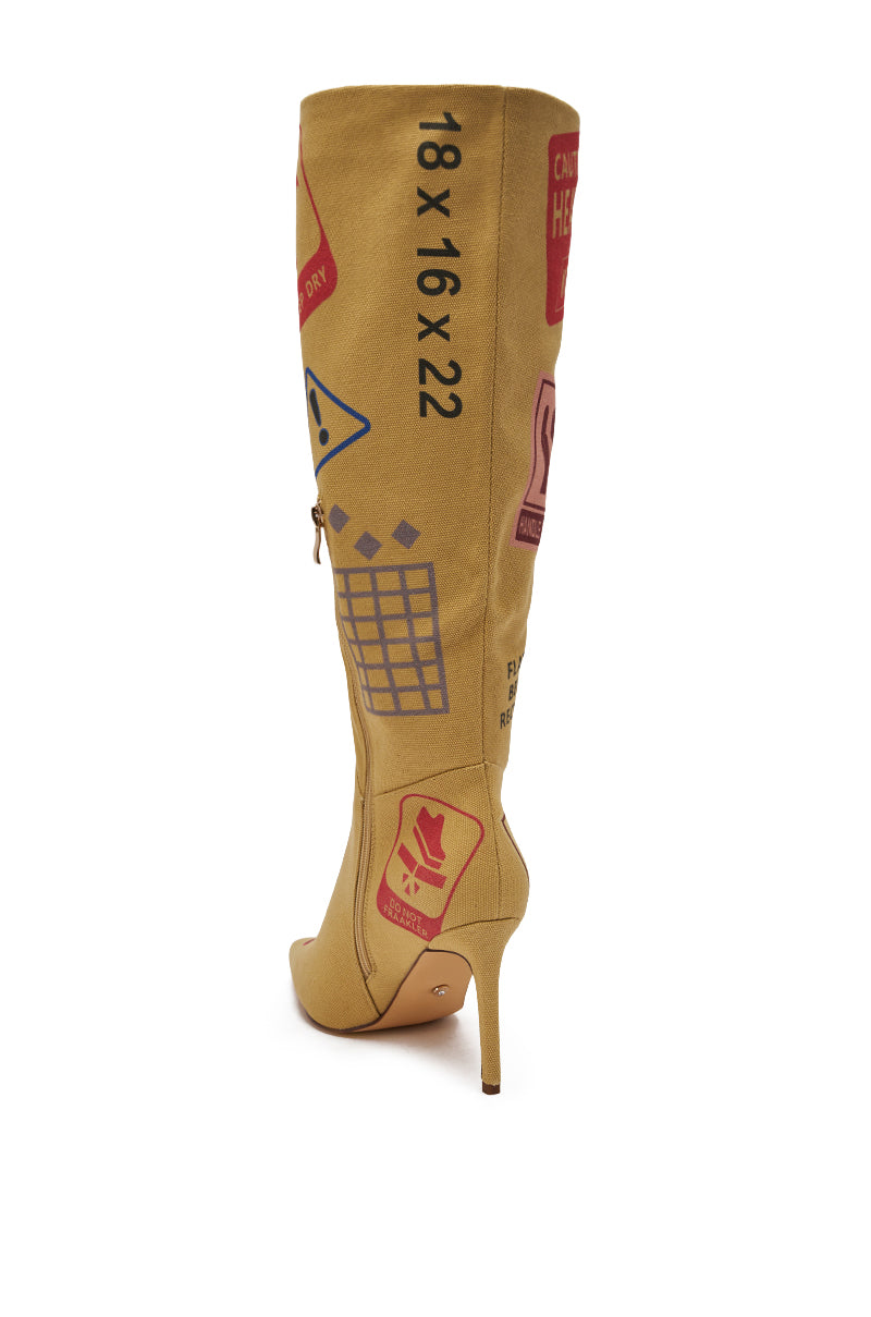 The AKIRA GOLD WHOLE PACKAGE TAN STILETTO BOOT is a tan, knee-high stiletto with a pointed toe, decorated with bold graphic red and blue symbols and "18 x 16 x 22" text along the side. 8