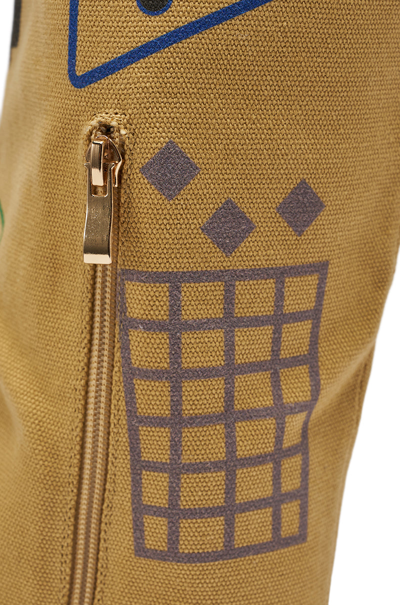 A close-up of the AKIRA GOLD WHOLE PACKAGE TAN STILETTO BOOT highlights its tan fabric, gold zipper, and gray and blue geometric patterns with a grid and four diamonds. 9