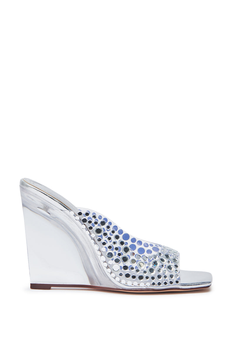 The AZALEA WANG WIDYA Silver Rhinestone Embellished PVC Wedge Sandal features a clear upper with silver rhinestone accents and a shiny, marble-patterned lucite wedge heel.