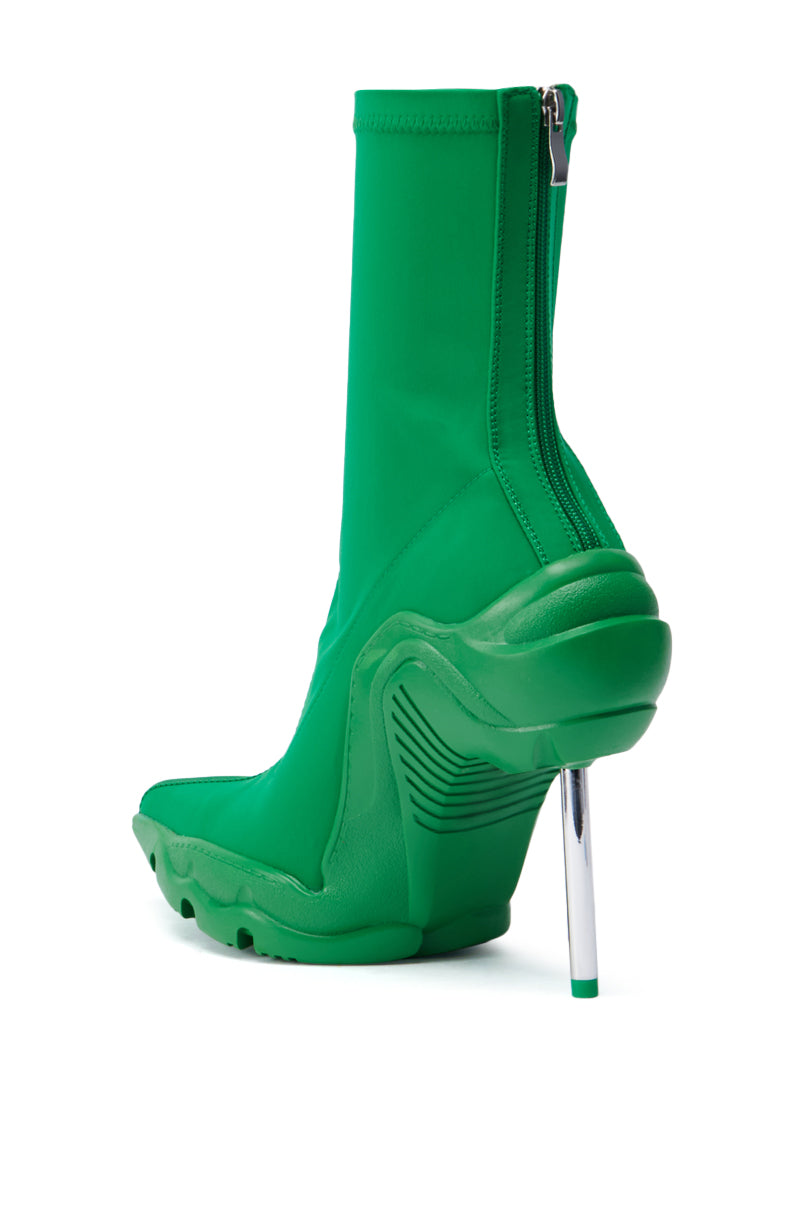 Introducing the AZALEA WANG WILBER BOOTIE WITH STRETCH NEOPRENE IN GREEN: a modern, stylish bootie featuring high-heeled, pointy toe design with a sleek metallic stiletto heel. It offers a textured sole for grip and comfort with stretch neoprene material, enhanced by a back zipper and a distinctive curved design on the side. 4