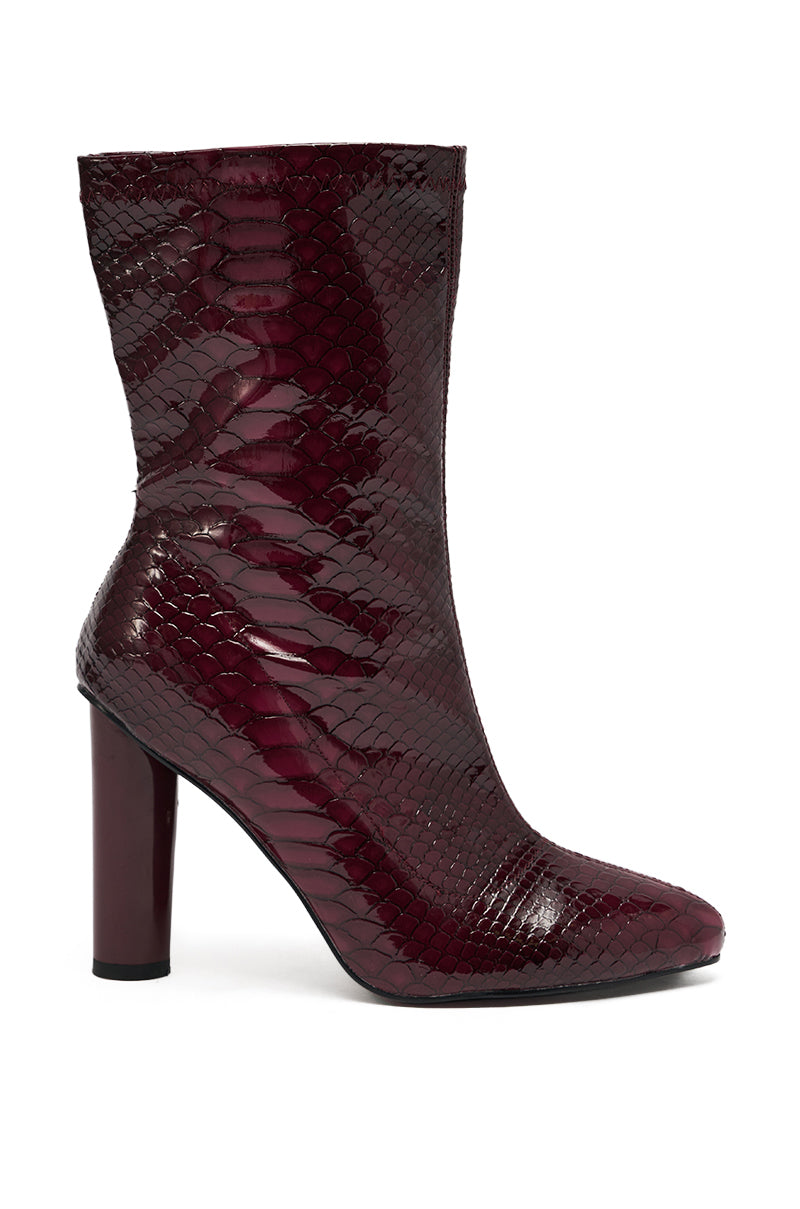 The AZALEA WANG WINGROVE Burgundy Chunky Heel Crocodile Bootie features a high-heeled, pointed-toe ankle boot in glossy burgundy faux croc with a block heel, shown in side profile against a white background.