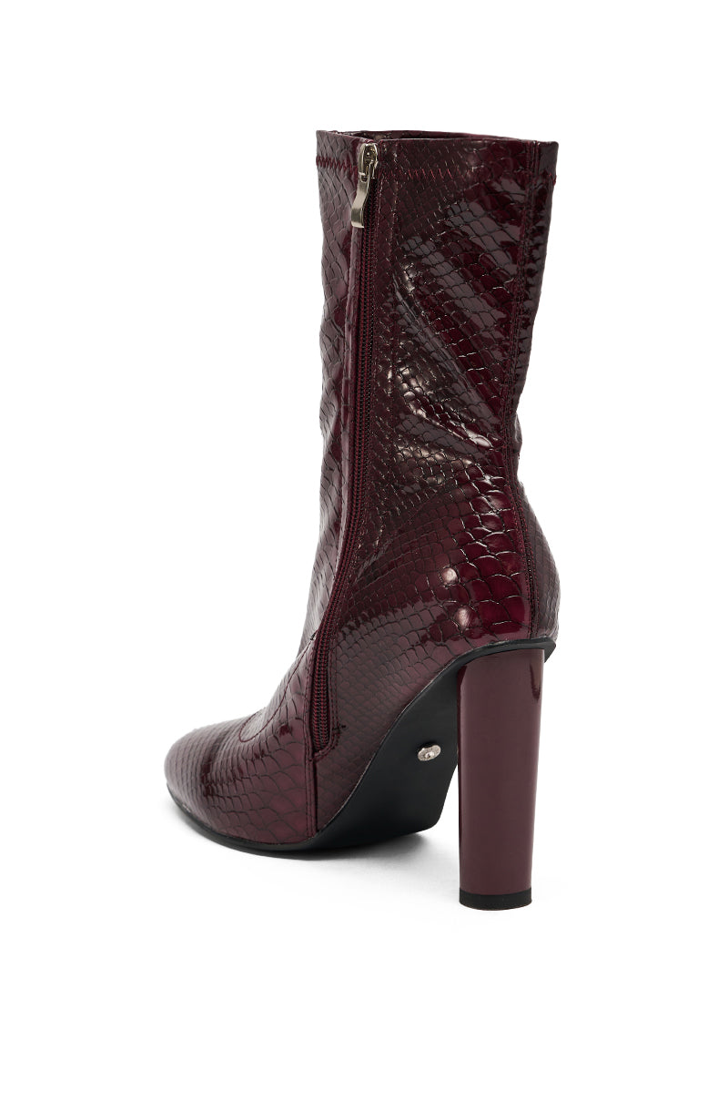 The AZALEA WANG WINGROVE BURGUNDY CHUNKY HEEL CROCODILE BOOTIE features a textured burgundy finish, pointed toe, side zipper, and high chunky heel, shown on a white background.