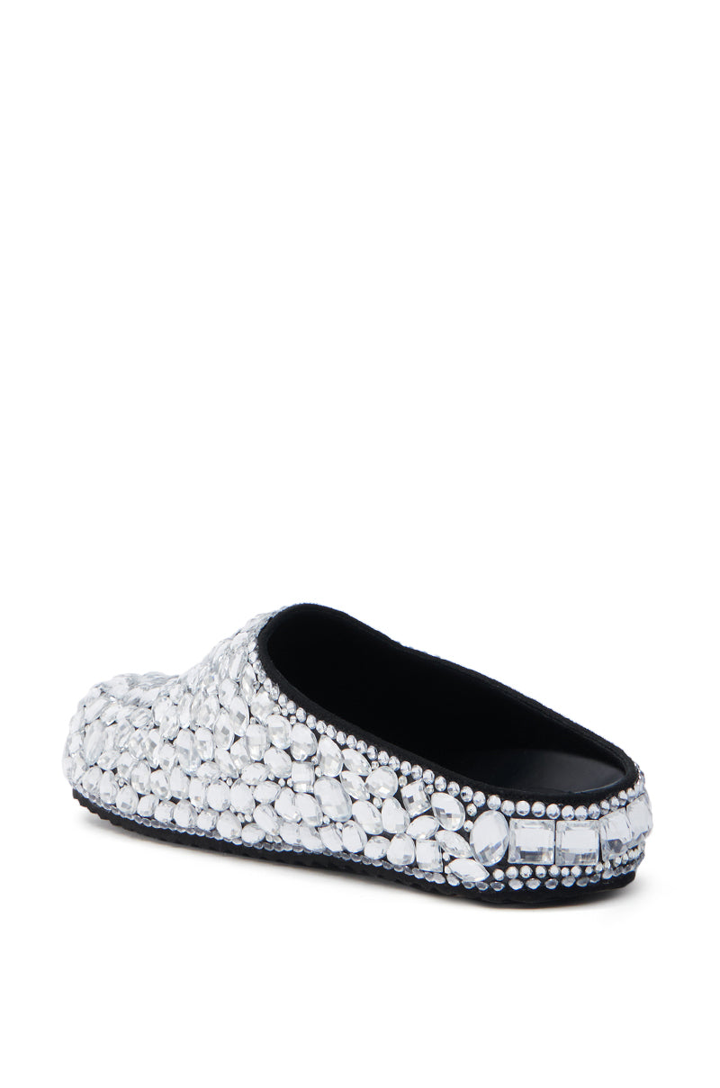 The AZALEA WANG WORLDCLASS EMBELLISHED SLIDE is made of faux leather and features a black interior contrasting elegantly with numerous shimmering gemstones covering its upper surface.