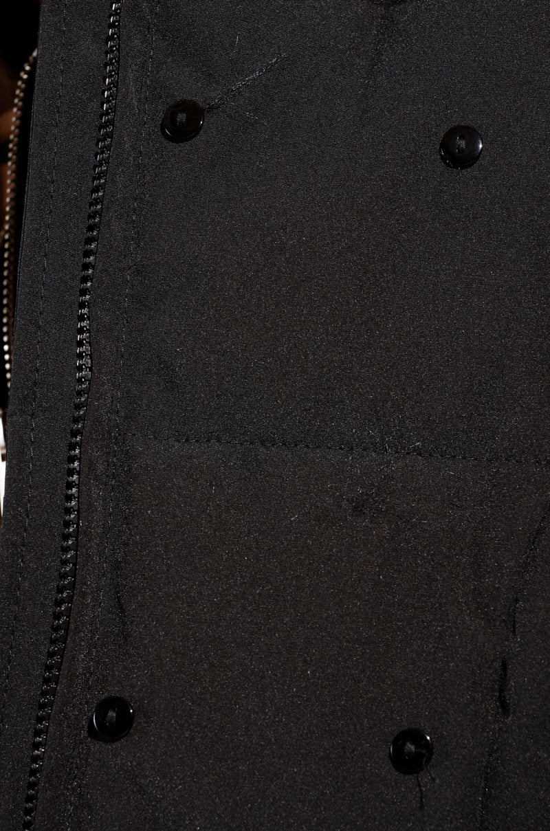 Close-up of the ARLETTE FUR TRIM PUFFER jacket in black, featuring a zipper on the left and black buttons on the right. The texture is clearly visible, making it perfect for a winter adventure.