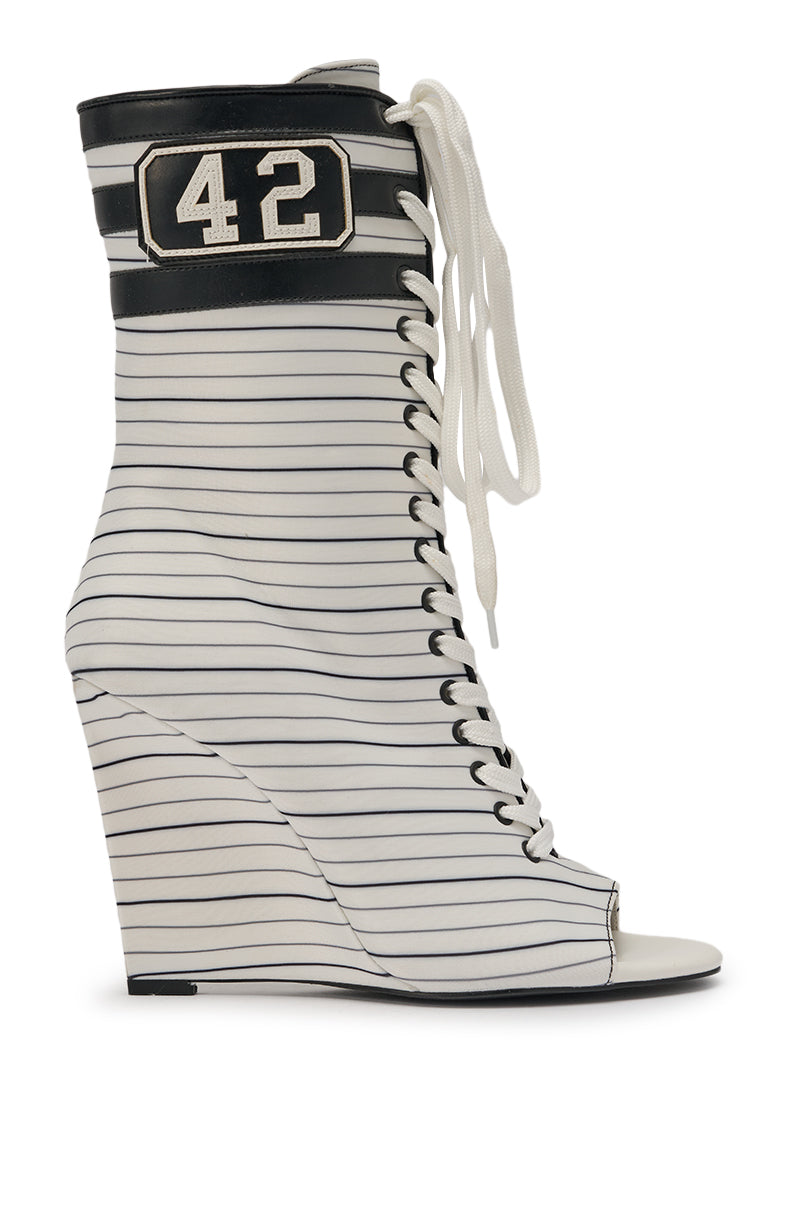 The AZALEA WANG WYATT WHITE STRIPED NAUTICAL OPEN TOE BOOTIE is a sporty, high-heeled wedge boot with black stripes on white, front laces, a peep toe, and a black "42" patch evoking classic baseball uniform style. 3