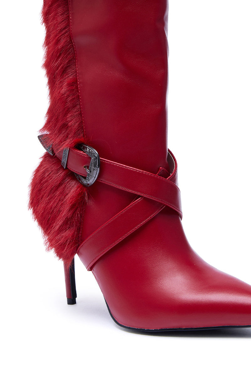 The AZALEA WANG WYLDER RED FUR BOOTIE is a chic red faux leather stiletto bootie featuring a pointed toe, side faux fur trim, decorative black buckle, and crisscross straps.