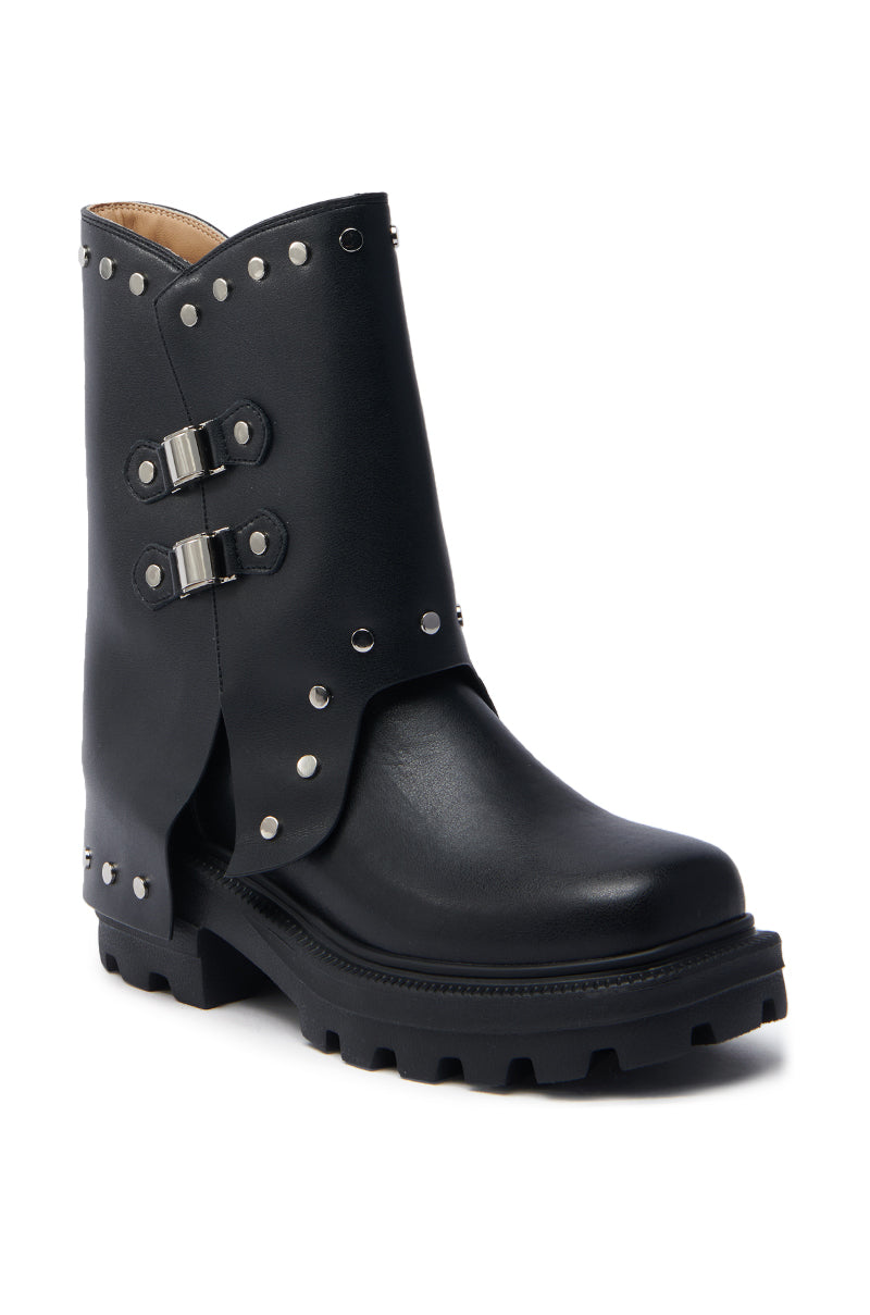 The AZALEA WANG XAVIER BLACK WITH METAL FLAT BOOTIE is a black faux leather ankle bootie with metallic stud trim, double buckle accents, a rugged treaded sole, and a chunky heel for a stylish and sturdy look.