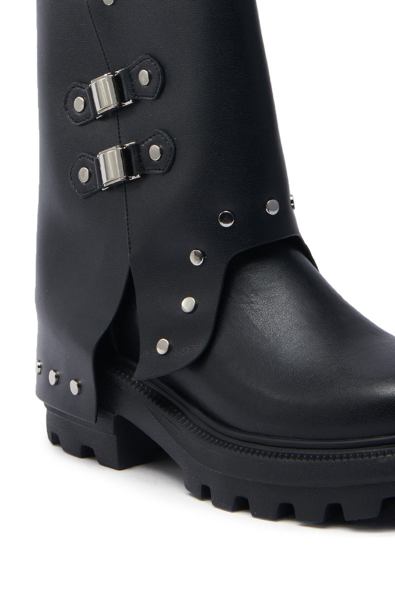 The AZALEA WANG XAVIER BLACK WITH METAL FLAT BOOTIE is a close-up of a faux leather bootie featuring chunky heels, decorative metallic studs, side buckles, and a thick sole with deep treads for a rugged yet stylish look.
