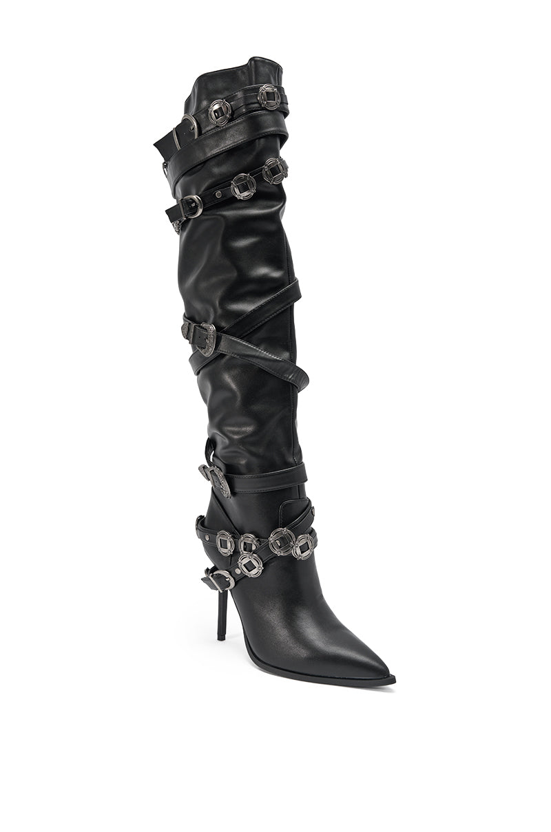 The AKIRA GOLD XERXES BLACK STILETTO METAL EMBELLISHED BOOT is a knee-high black faux leather boot with a pointed toe, high stiletto heel, and multiple silver buckles and straps decorating the shaft. 4