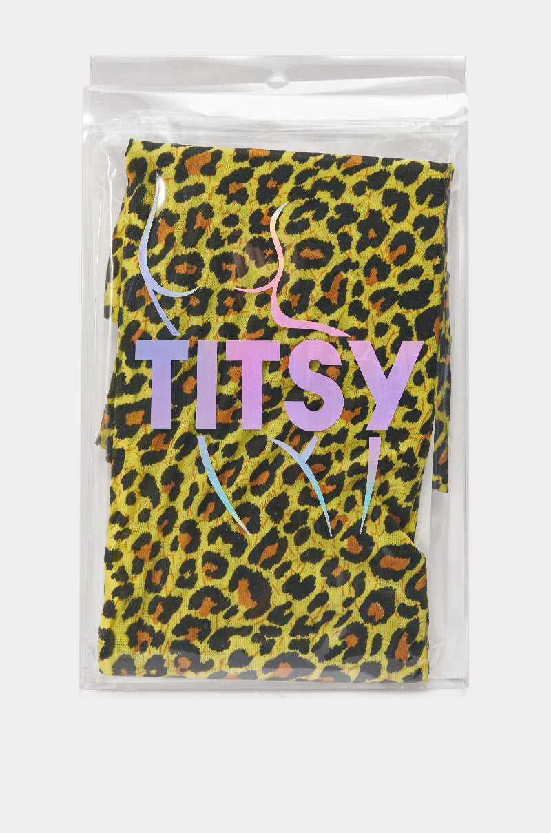 CHEETAH GURL TIGHTS, with bold “TITSY” in purple-pink gradient and a minimalist woman’s outline above, come in a clear plastic bag. Their yellow cheetah print makes for striking statement tights. 4