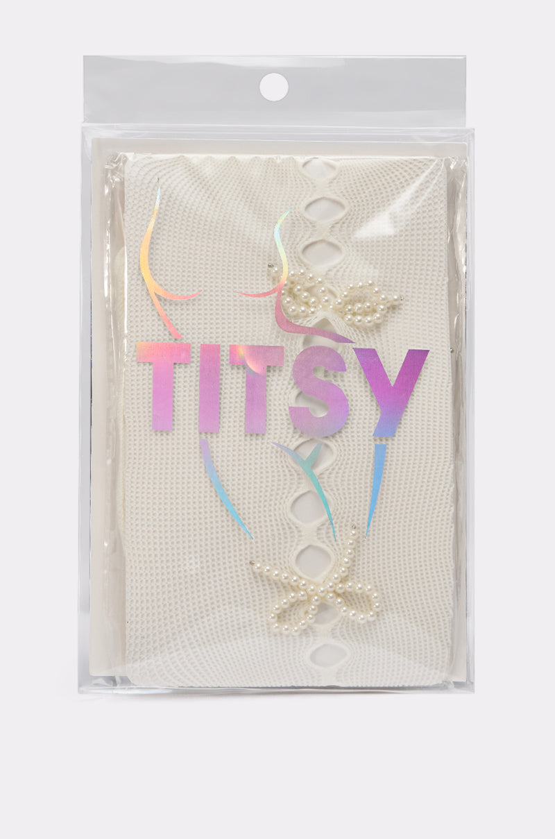 The ANGEL SEASON TIGHTS, white mesh adorned with pearls and inspired by pearl bow tights, come in a clear plastic bag featuring "TITSY" printed in iridescent letters on the front. 5