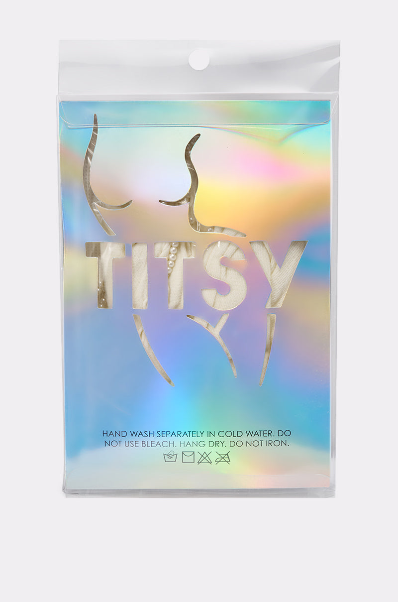 The holographic packaging features a minimalist outline of a woman’s body and bold "TITSY" lettering. Care instructions at the bottom make ANGEL SEASON TIGHTS ideal for fans of mesh tights or pearl bow embellishments. 7