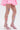 Model wears the ITS POPPIN EMBELLISHED TIGHTS—white fishnet tights with vibrant floral accents—paired with a pink skirt and strappy pink heels, shown waist down against a plain background.