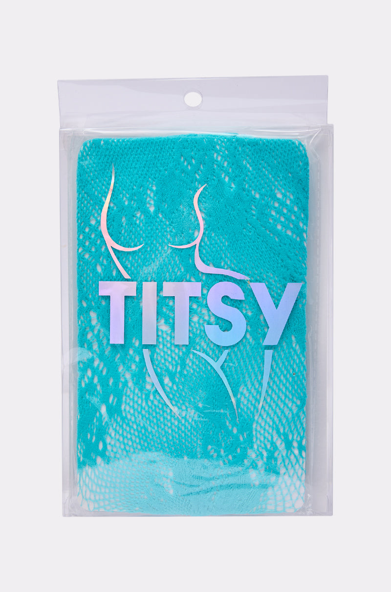 A pair of lacy aqua-blue fishnet floral tights, branded "TITSY" in iridescent letters, showcased on clear LUXE LIVING TIGHTS packaging featuring an abstract outline of a woman's torso.