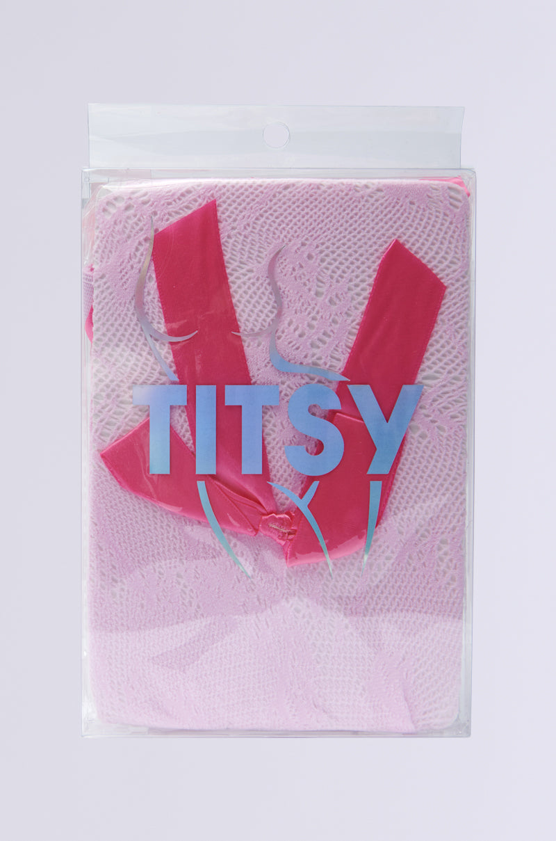 PRETTY IN PINK BOW TIGHTS are wrapped in clear packaging with bold pink diagonal stripes and "TITSY" in large blue letters. The pink lace fabric has satin bow appliques, and the plain light gray background contrasts with the bubblegum pink nylon theme. 4