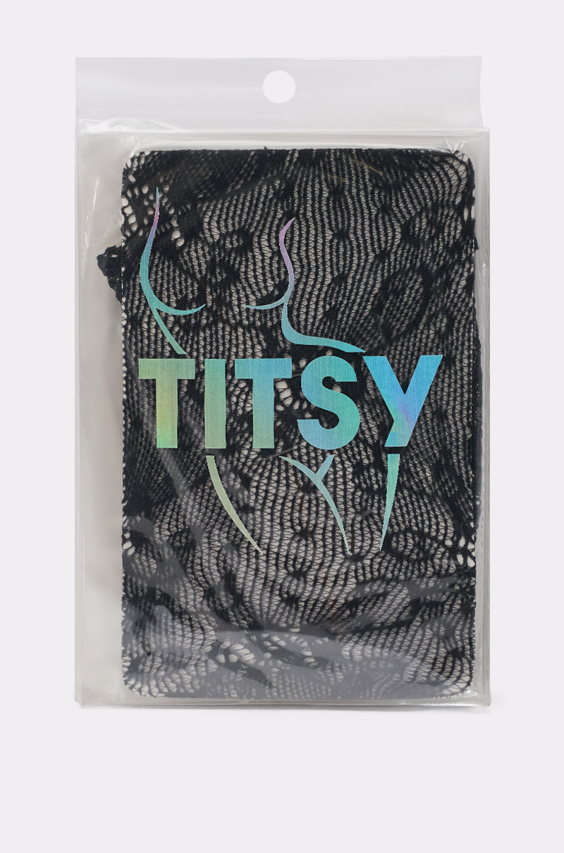 A transparent plastic package containing CLASSY VIBES THIGH HIGH STOCKINGS IN BLACK, featuring black lace fabric, "TITSY" in iridescent letters, and an outline of a woman's torso printed on the front. 2
