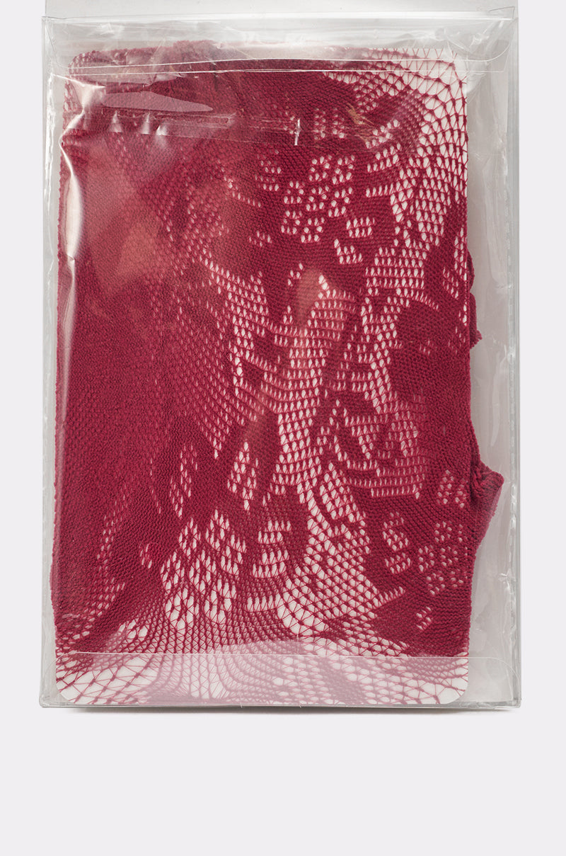 A pair of FOR THE NIGHT LACE TIGHTS, featuring intricate red floral lace, is folded and packaged in a clear plastic bag that displays the detailed pattern. 3