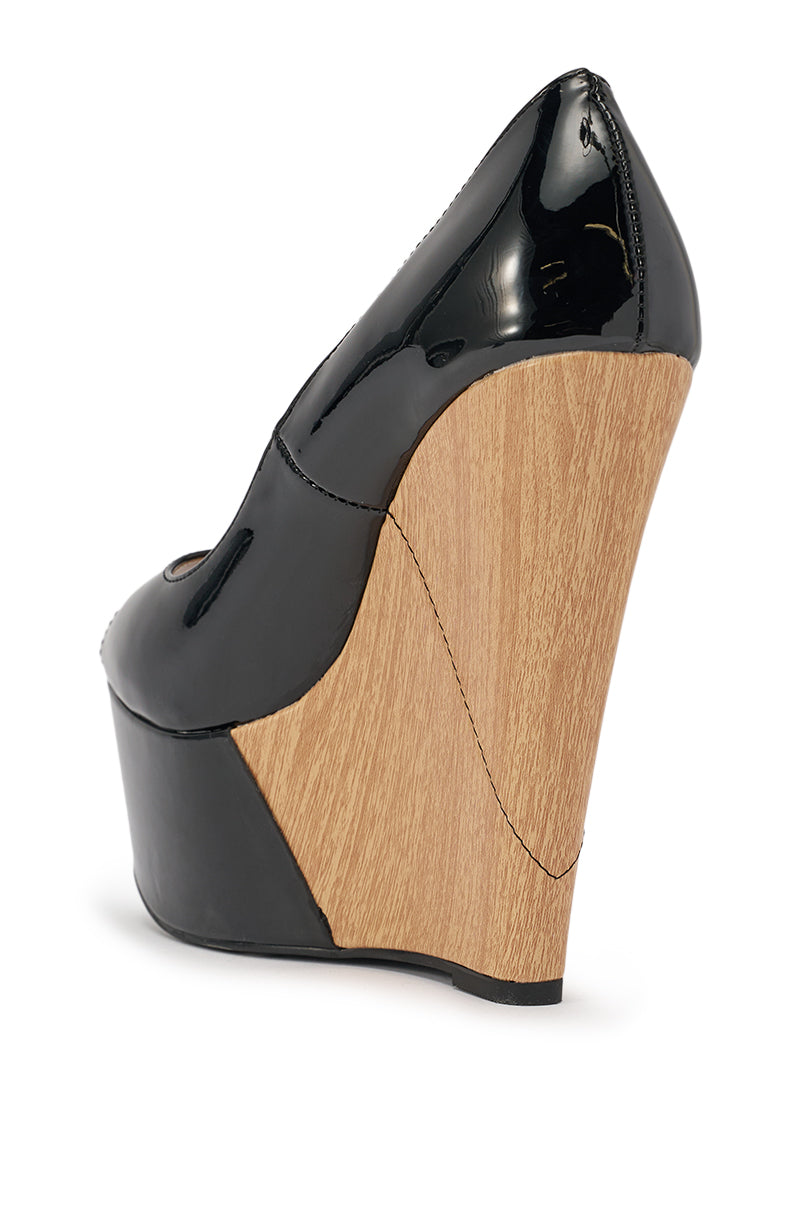 The AKIRA GOLD XOE BLACK WEDGE OPEN TOE PUMP features a shiny black faux leather upper, thick light wood-textured platform sole, and open toe, shown in a side view against a white background. 4