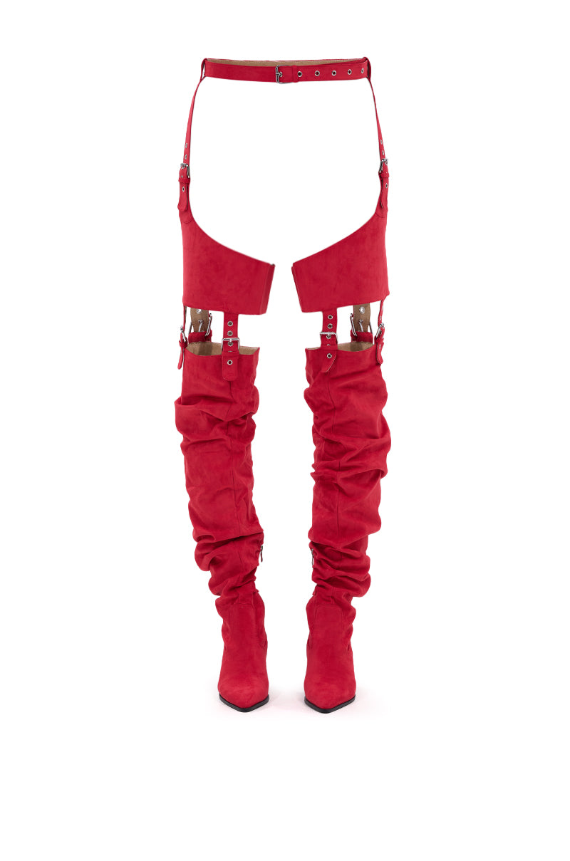 The AZALEA WANG XOMARIA RED FAUX SUEDE WESTERN CHAP BOOT features bold red faux suede, large hip cutouts, ruched legs, and is connected to a matching waist belt by straps for a striking Western-inspired look. 6