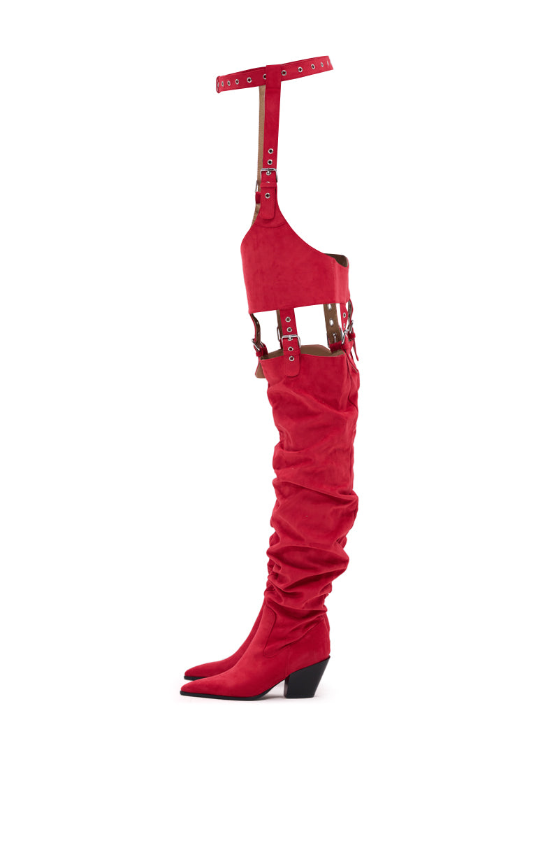 The AZALEA WANG XOMARIA RED FAUX SUEDE WESTERN CHAP BOOT features a pointed toe, ruched thigh-high shaft, chunky heel, and multiple buckled straps connecting to a matching high leg harness with belt. 7