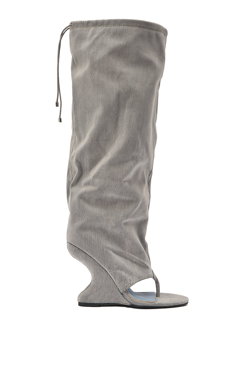 The AZALEA WANG XYLAH GREY WEDGE GLADIATOR SANDAL features a tall gray slouchy suede shaft, open toe with thong detail, and a curved wedge heel—ideal for those who love bold, knee-high sandal boots. 6