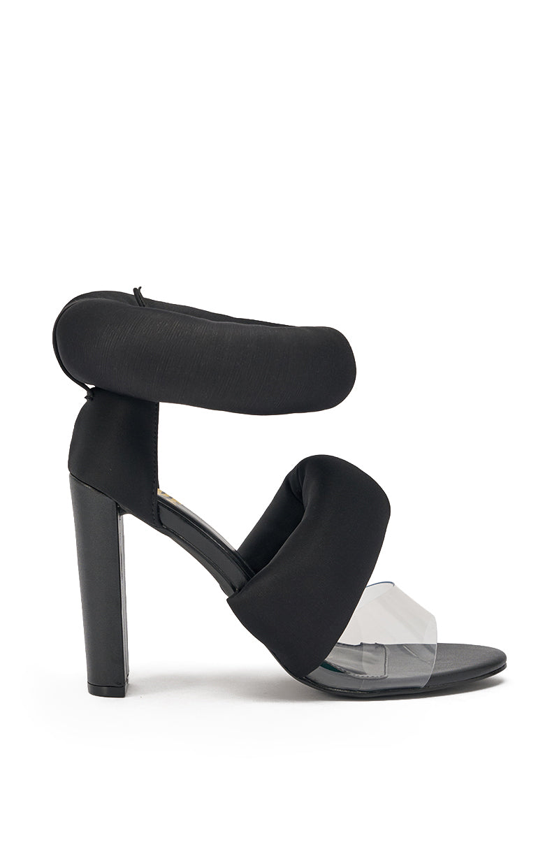 The YANIX BLACK PUFF SLIP ON SANDAL features black chunky heels, puffy satin straps, a thick cushioned ankle strap, a padded instep band, clear accent across the toes, closed heel, and an open almond toe design. 3
