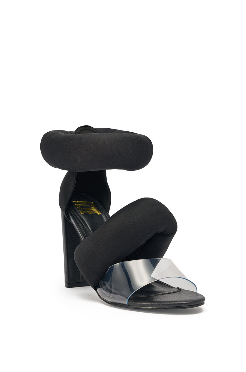 The YANIX BLACK PUFF SLIP ON SANDAL features puffy straps at the ankle and upper foot, a clear wide strap over the open almond toe, and a sculptural chunky heel for standout modern style. 4