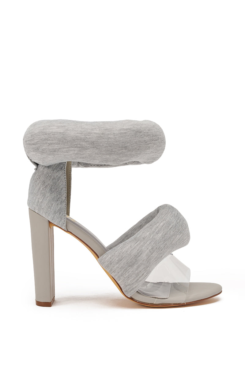 The YANIX GREY PUFF SLIP ON SANDAL features jersey knit grey ankle and toe straps, a clear plastic front band, and a stylish block heel in light grey for added flair. 3