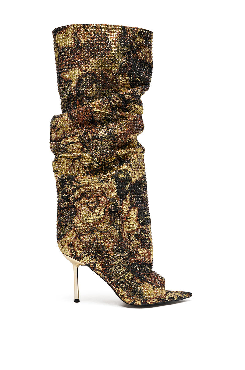 The AZALEA WANG YARDLEY MULTI GOLD RHINESTONE COVERED OPEN TOE BOOT is a slouchy, knee-high stiletto featuring an open toe and textured gold, black, and brown patterned fabric with sparkling rhinestones.